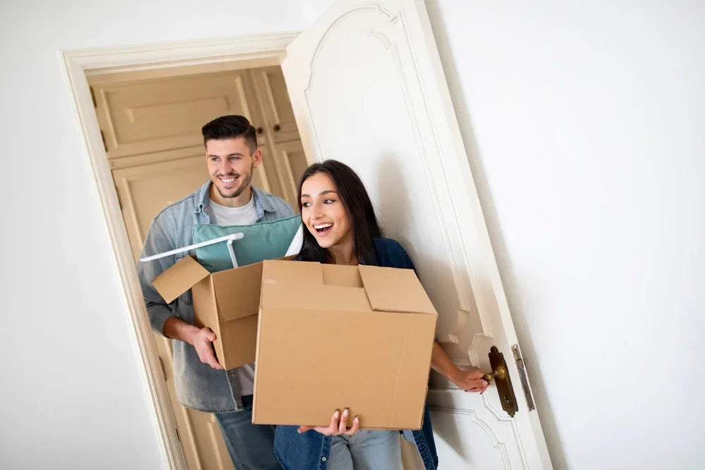 Coppia felice che entra in casa con scatoloni simbolo di nuova convivenza dell' ex coniuge.
