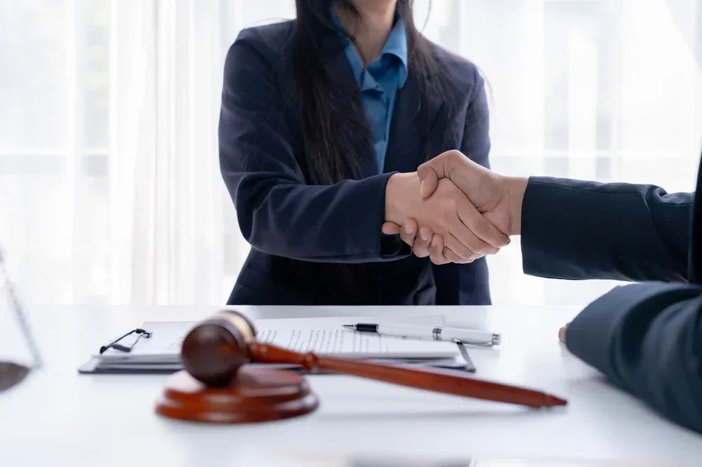 Donna avvocato e Uomo investigatore privato si stringono la mano in accordo per un servizio di indagine per studi legale